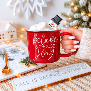 red ceramic mug that says believe and choose joy for Christmas
green Christmas coffee mug with inspirational holiday saying
cute festive mug for drinking coffee by the Christmas tree
cozy ceramic Christmas cup for hot chocolate and winter drinks
farmhouse style Christmas mug for kitchen decor