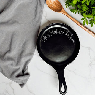 Ready-to-gift kitchen spoon rest set with decorative ribbon
Dishwasher safe ceramic spoon rest with funny baking message