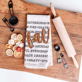 fall words towel used as backdrop for thanksgiving desserts
autumn text dish towel with black fonts and bold script
fall kitchen cloth featuring list of seasonal comforts
autumn cozy sayings towel beside copper cookware