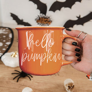 fall themed ceramic cup for coffee or tea
autumn kitchen decor with orange mug
pumpkin spice drinkware for fall lovers
cozy orange mug next to knit blanket