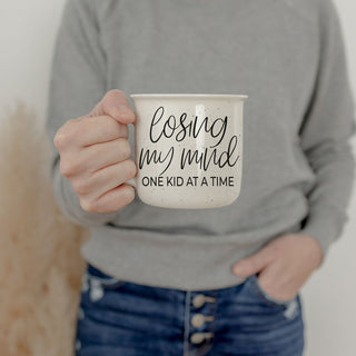 honest mom life coffee cup with playful saying
cute gift for mom who laughs through chaos
funny mug for moms who are mentally done
cozy sweatshirt and motherhood quote mug photo
mom coffee bar decor with losing my mind mug
gift for new mom learning the chaos of kids