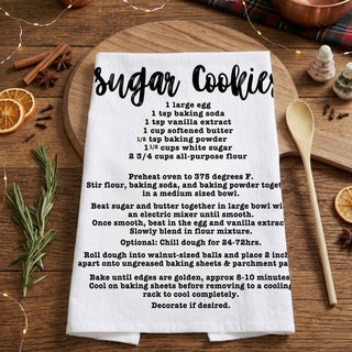 christmas kitchen towel with recipe in cozy home
holiday towel held in front of decorated christmas tree
kitchen towel recipe styled outdoor winter scene
christmas towel styled with lights and garland decor
recipe kitchen towel lifestyle holiday aesthetic