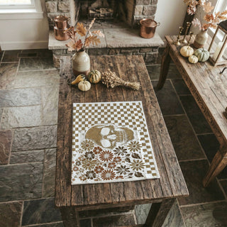 neutral spooky decor towel with skull and wildflowers
earth tone halloween towel with ghost illustration
checkered fall towel with skull graphic for entryway ladder