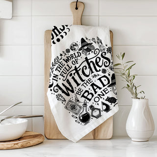 in a world full of witches be the bad one towel on cutting board
snarky witch kitchen décor towel for spooky season
witchcore kitchen towel with broom moon and potion illustrations